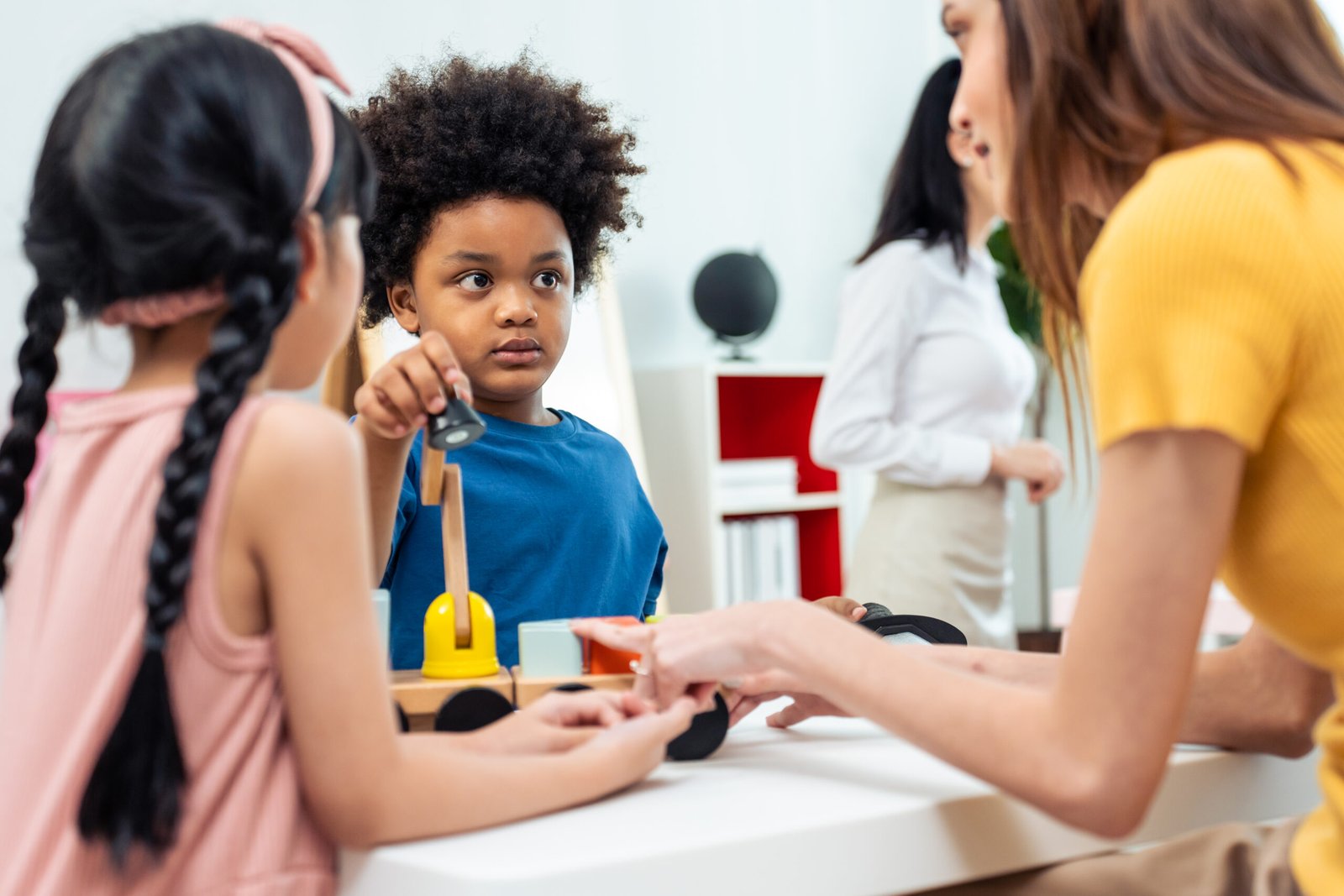 Children participating in a classroom activity with an adult Children participating in a classroom activity with an adult